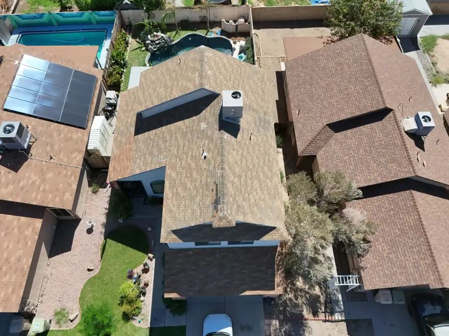 House with weathered brown shingles before replacement.